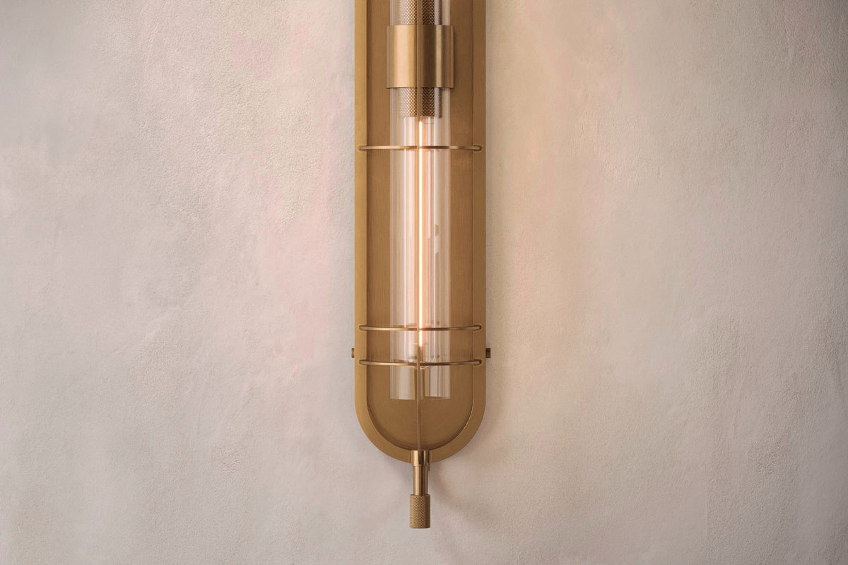 Front close-up view of the designer Astragal Sconce, a nautically-inspired wall light featuring hand-finished solid brass and heavy glass for authentic, artisanal elegance.