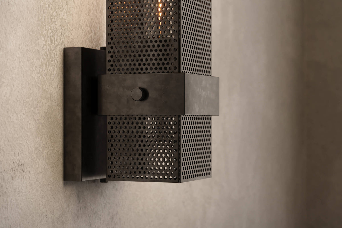 Close-up view of the architectural designer Baffle Sconce, an industrial-inspired wall light featuring hand-finished perforated steel for genuine, utilitarian elegance.