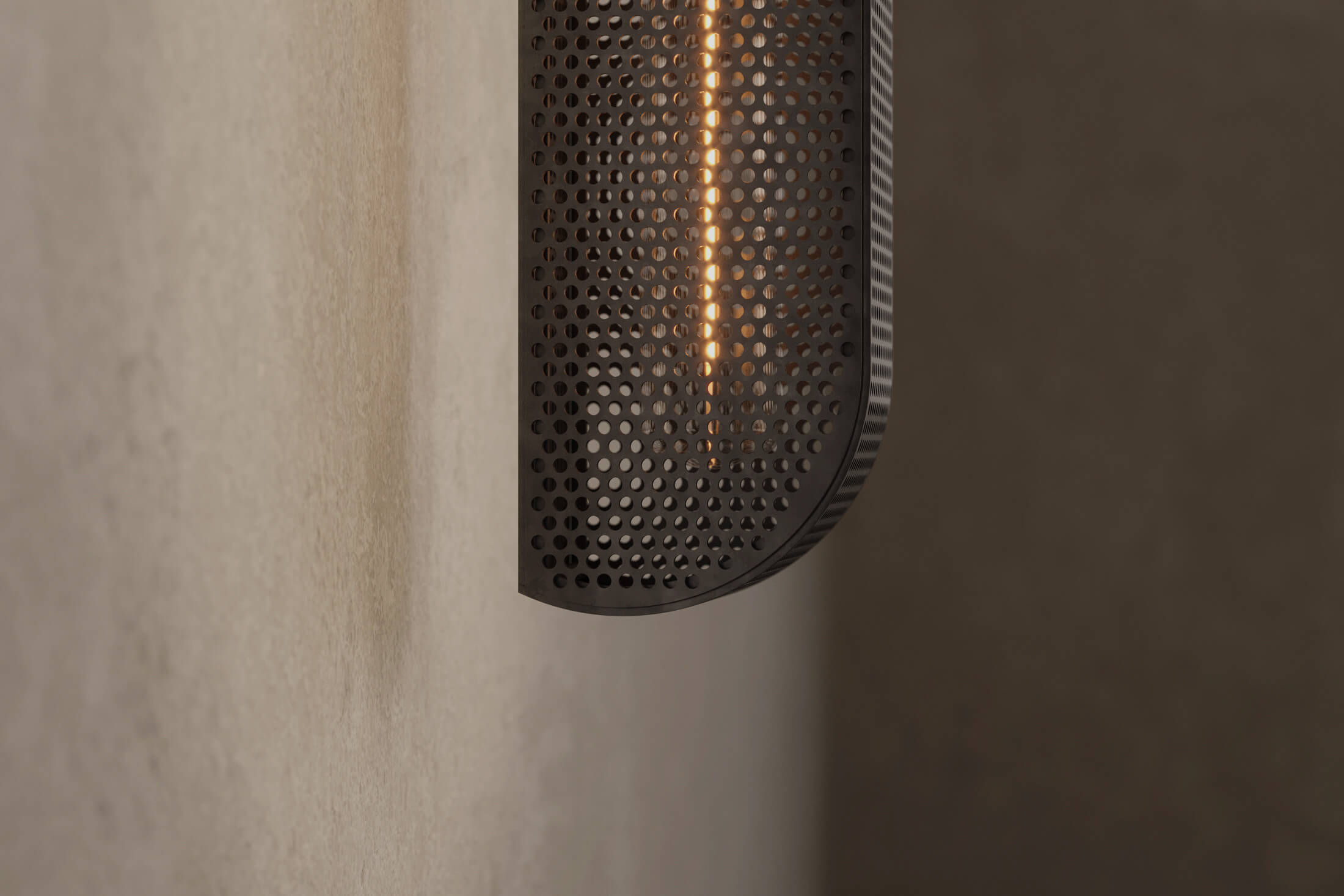 Close-up view of the modern designer Baffle Sconce (Tandem), an industrial-inspired wall light featuring hand-finished perforated steel for genuine, utilitarian elegance.