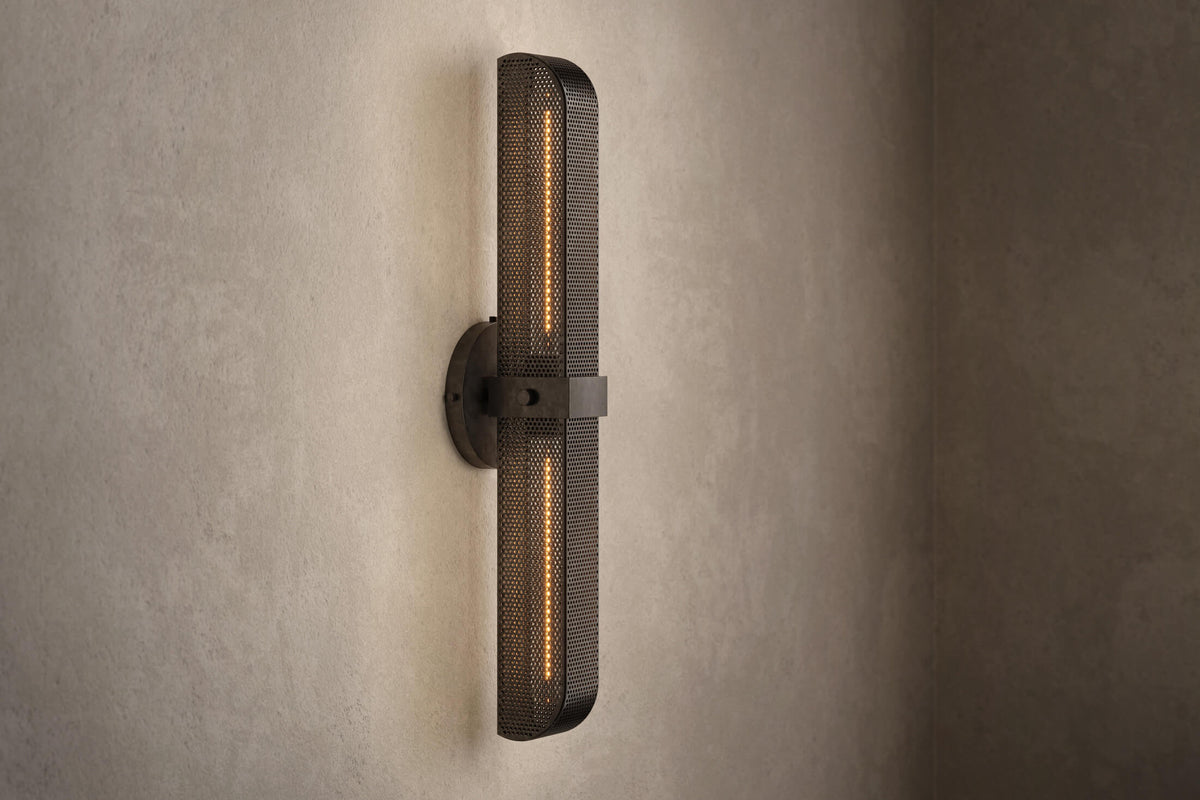 Angled view of the designer Baffle Sconce (Tandem), an industrial-inspired wall light featuring hand-finished perforated steel for genuine, utilitarian elegance.