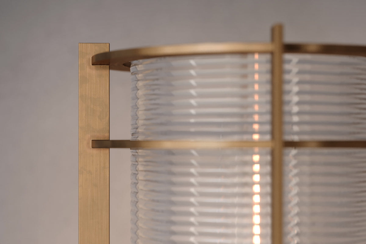 Close-up view of the architectural designer Batten Sconce, a nautically-inspired wall light featuring hand-finished solid brass and heavy glass for authentic, artisanal elegance.