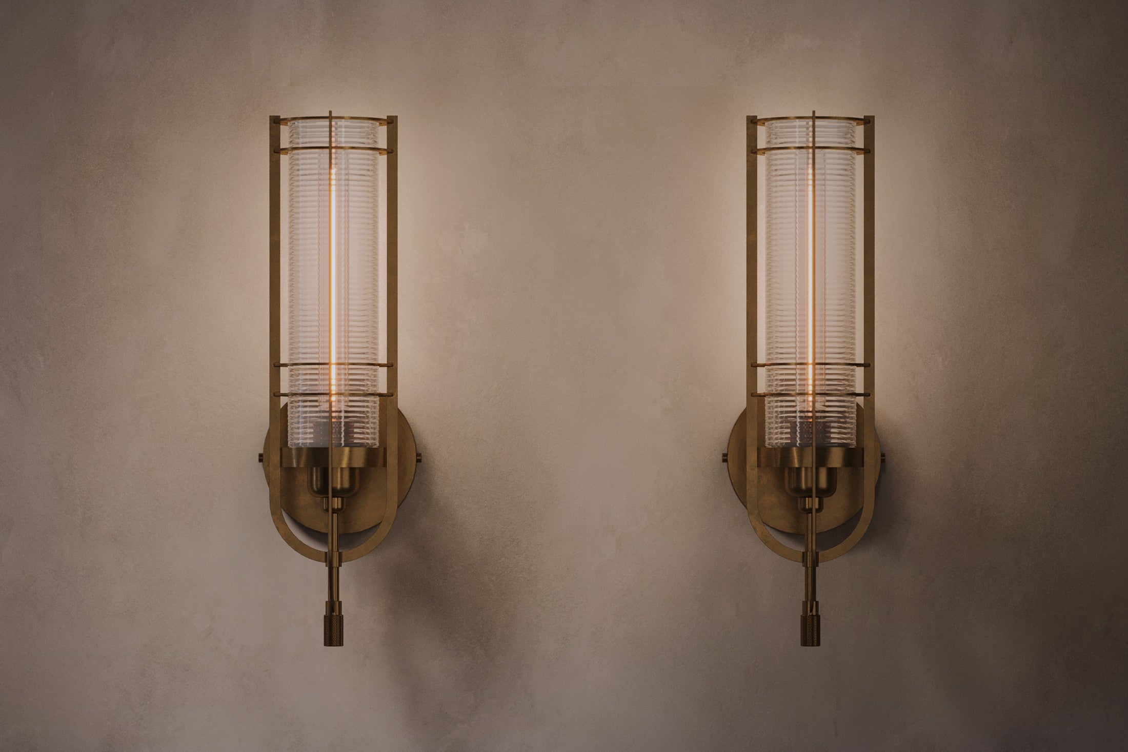 Architectural lighting featuring two Batten Sconce fixtures in hand-finished solid brass and ribbed glass.
