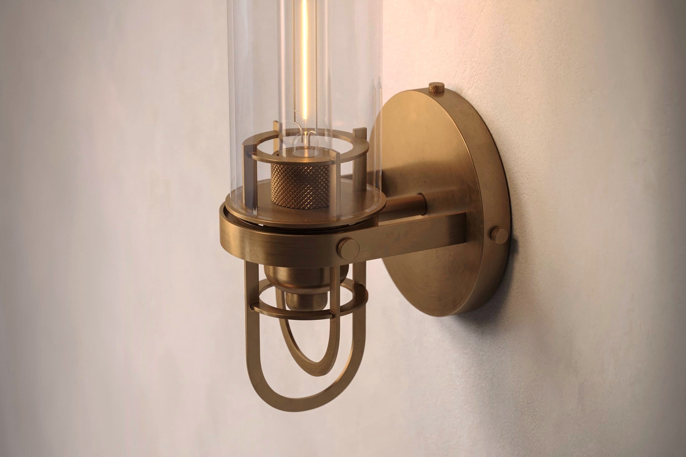 Close-up of the Beacon Sconce, a modern wall light featuring hand-finished solid brass and a heavy glass cylinder.