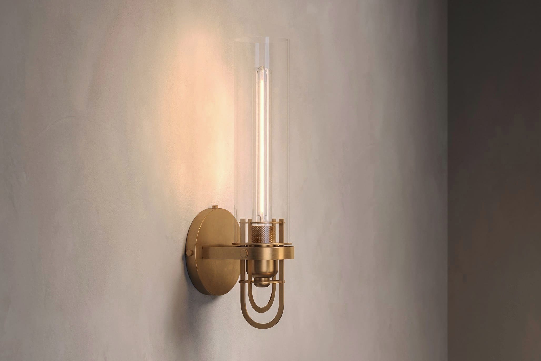 Architectural lighting featuring the Beacon Sconce, a modern wall light in hand-finished solid brass and a heavy glass cylinder.