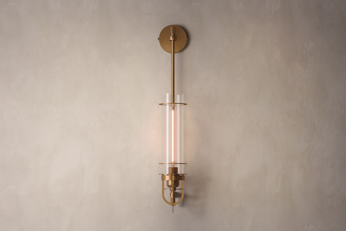 Front view of the designer Belay Sconce, a nautically-inspired wall light featuring hand-finished solid brass and heavy glass for authentic, artisanal elegance.