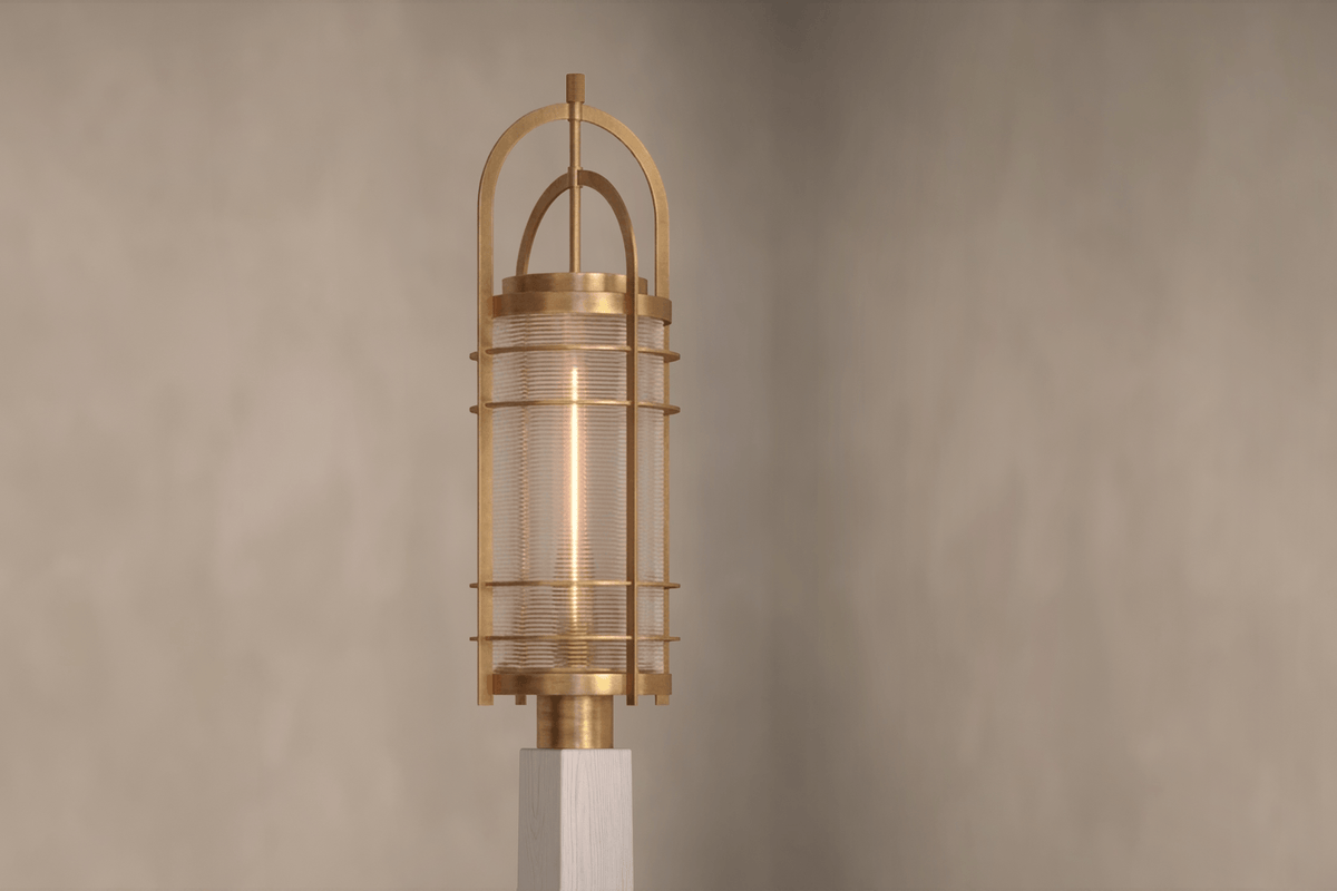 Angled view of the designer Binnacle Post Lamp, a nautically-inspired outdoor light featuring hand-finished solid brass and heavy glass for authentic, artisanal elegance.
