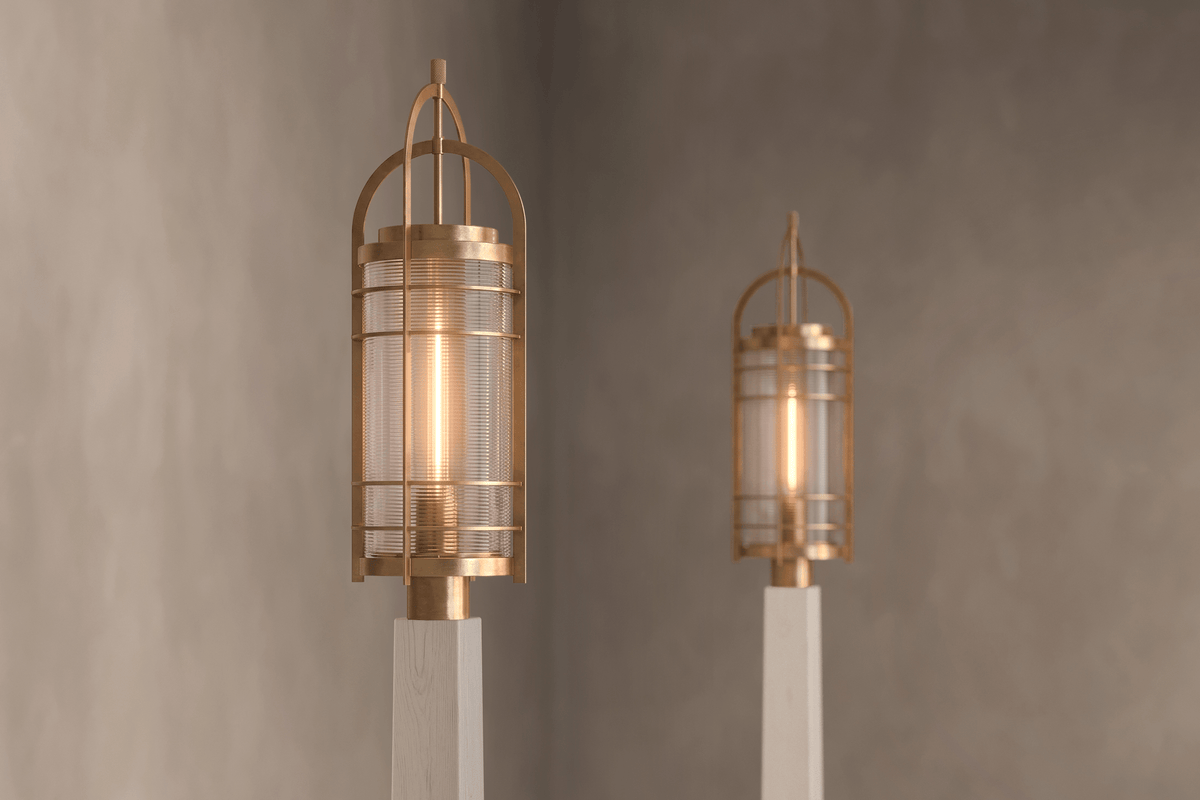 Angled view of pair of designer Binnacle Post Lamps, nautically-inspired outdoor lights featuring hand-finished solid brass and heavy glass for authentic, artisanal elegance.