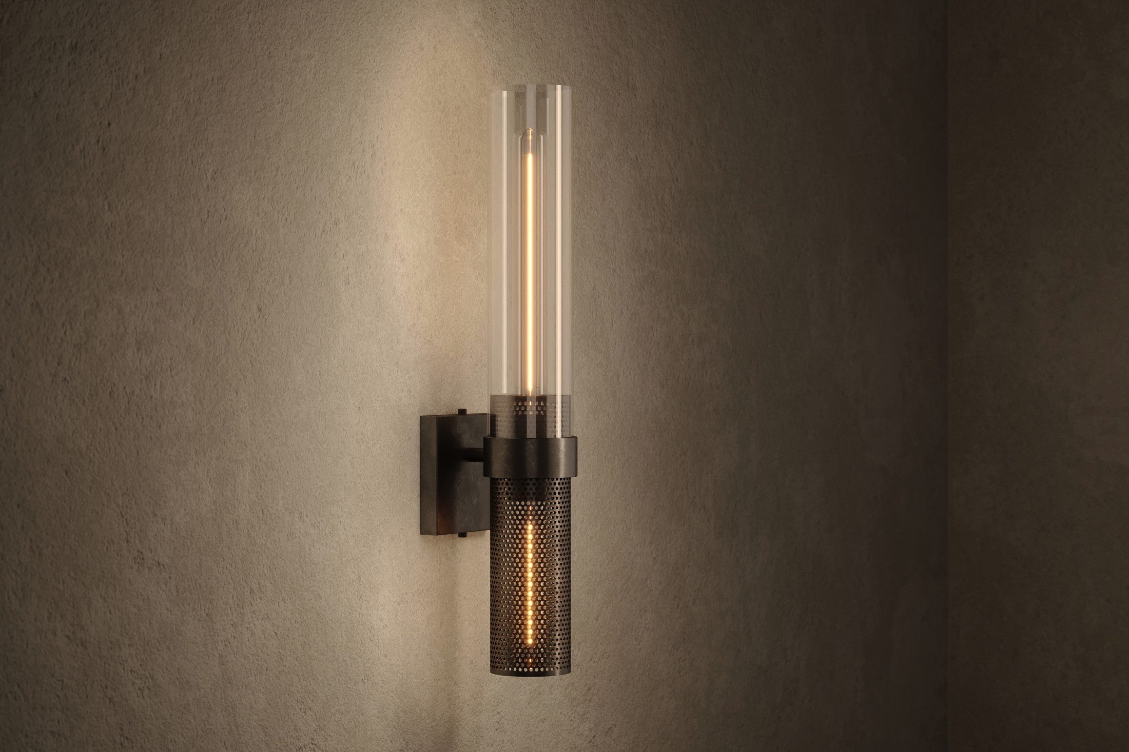 Modern architectural lighting featuring the Carbide Sconce, a wall sconce in hand-finished perforated metal and glass.
