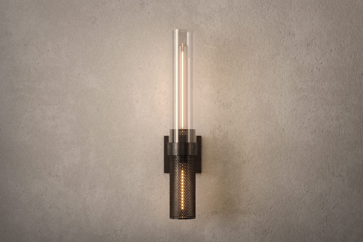 Front view of the designer Carbide Sconce, an industrial-inspired wall light featuring hand-finished perforated steel and heavy glass for genuine, utilitarian elegance.