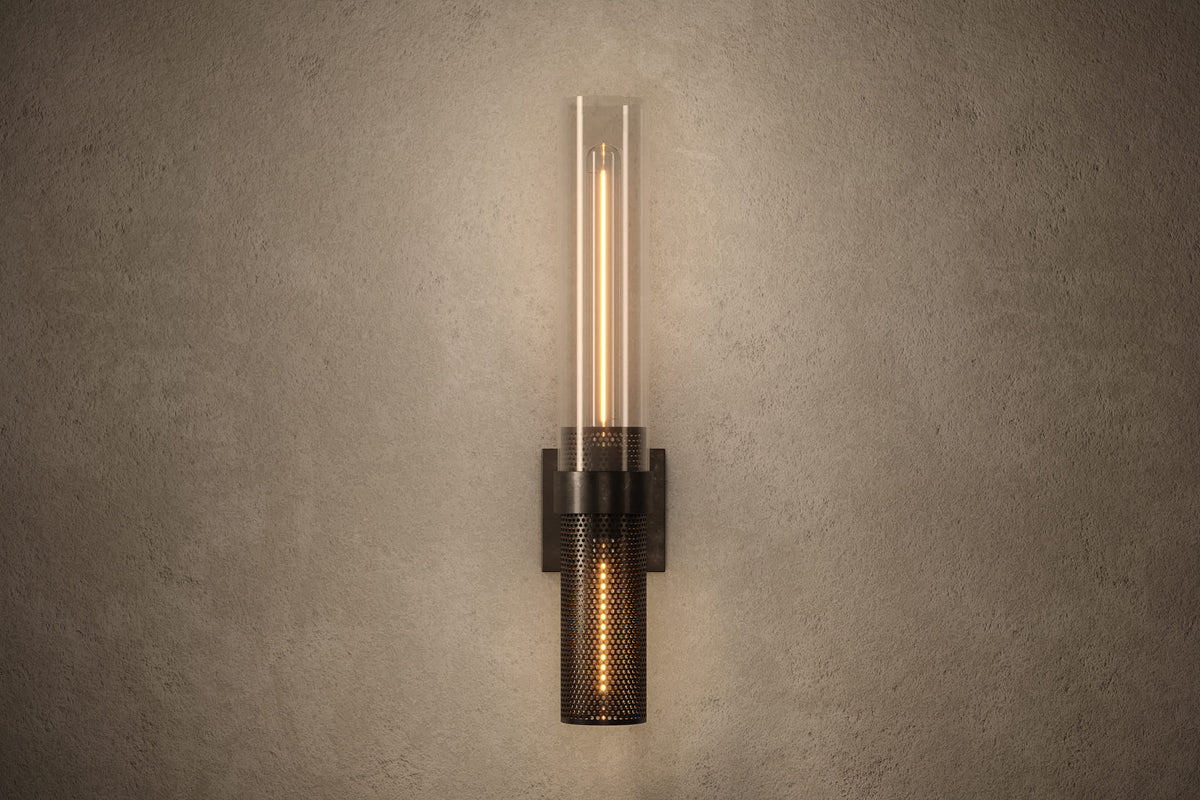Front view of the architectural designer Carbide Sconce, an industrial-inspired wall light featuring hand-finished perforated steel and heavy glass for genuine, utilitarian elegance.