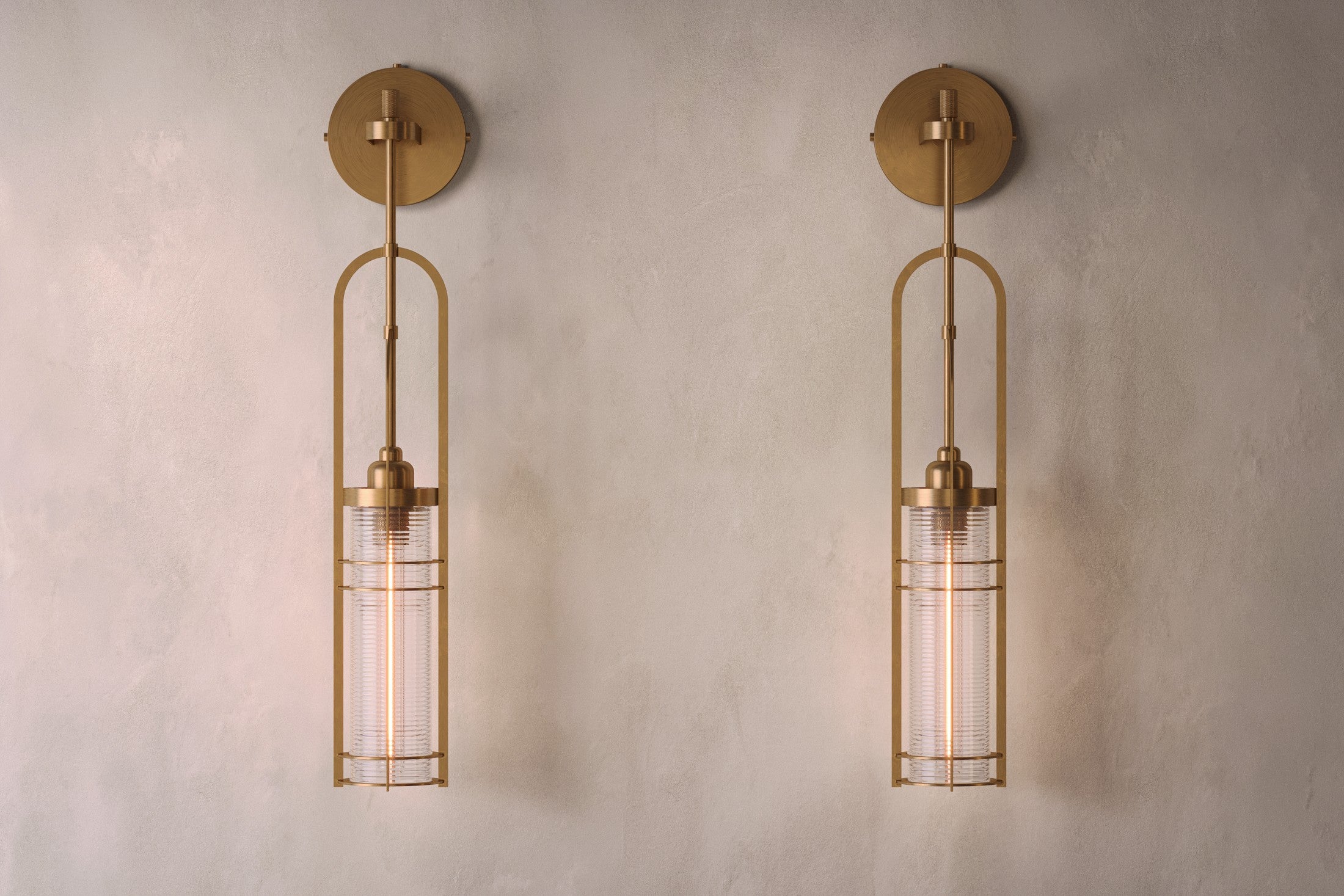 Architectural lighting featuring two Halyard Axial Sconce fixtures in hand-finished solid brass and glass.