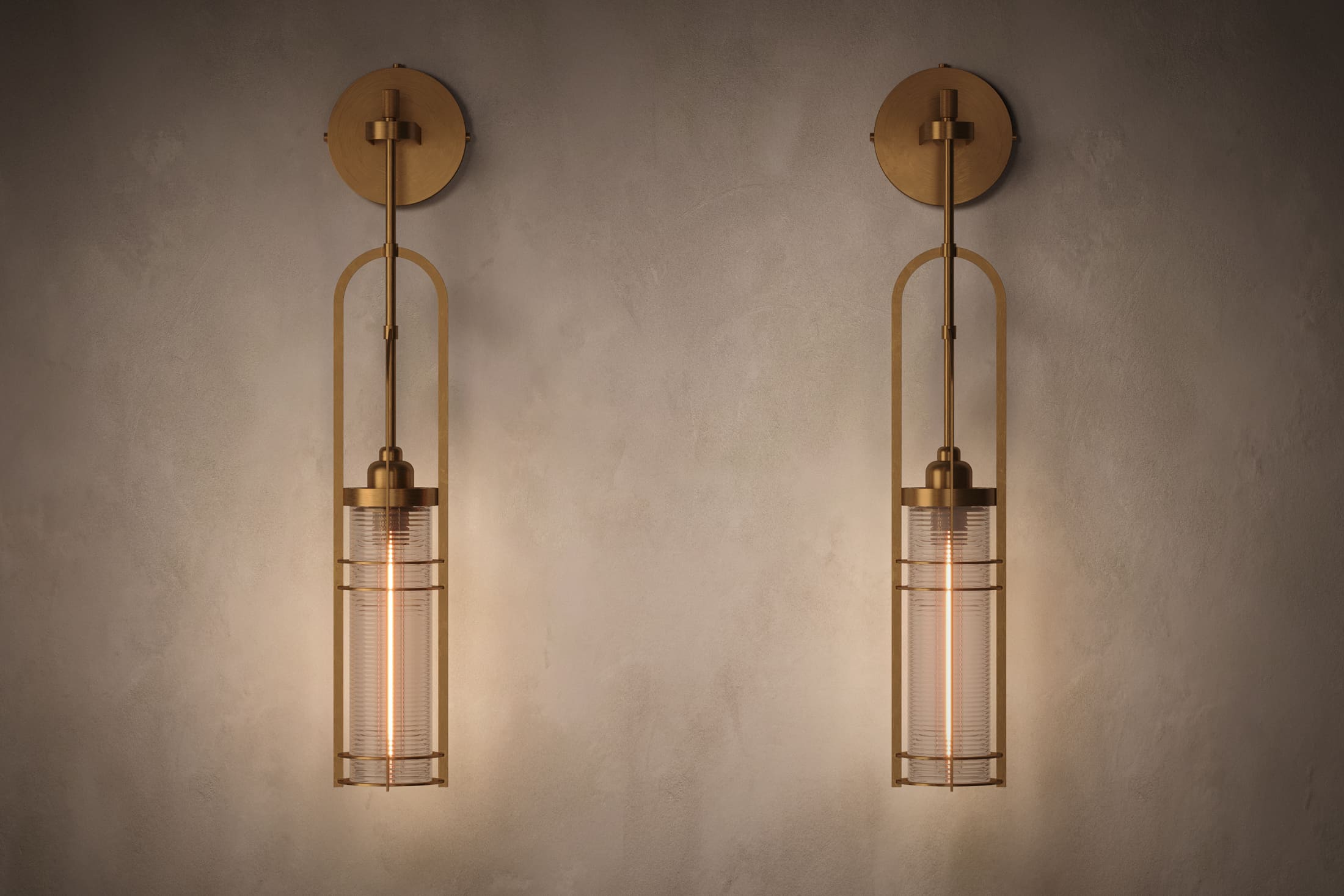 Architectural lighting featuring two Halyard Axial Sconce fixtures in hand-finished solid brass and glass.