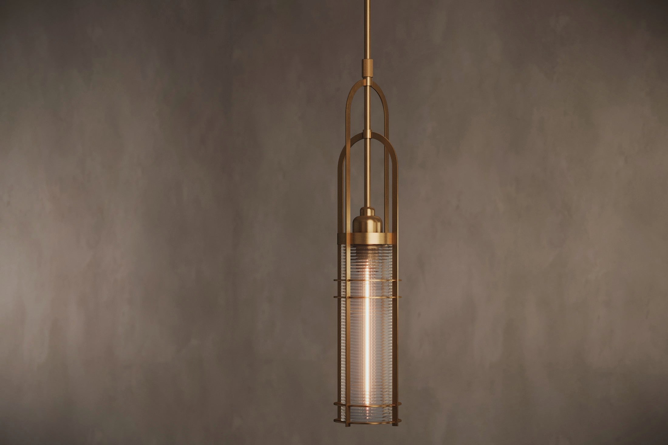 Modern architectural lighting featuring the Halyard Pendant, a pendant light in hand-finished solid brass and glass.