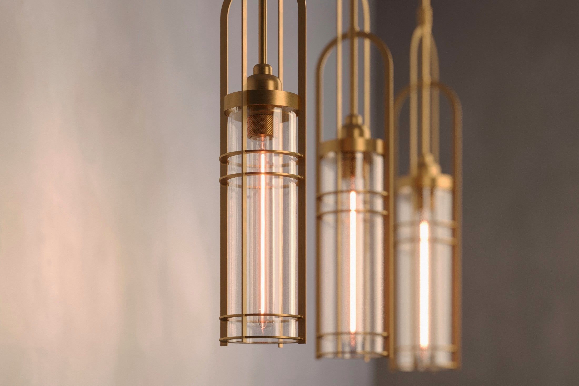 Decorative lighting featuring multiple Halyard Pendant fixtures in hand-finished solid brass and glass.