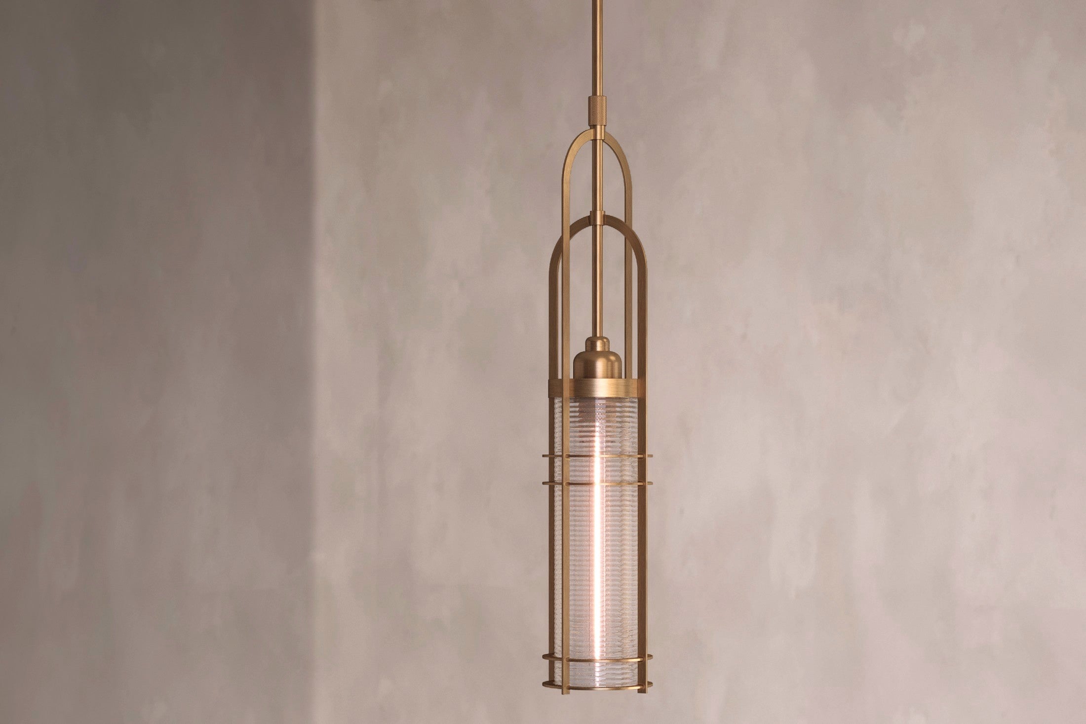 Close-up of the Halyard Pendant, a modern pendant light featuring hand-finished solid brass and glass.