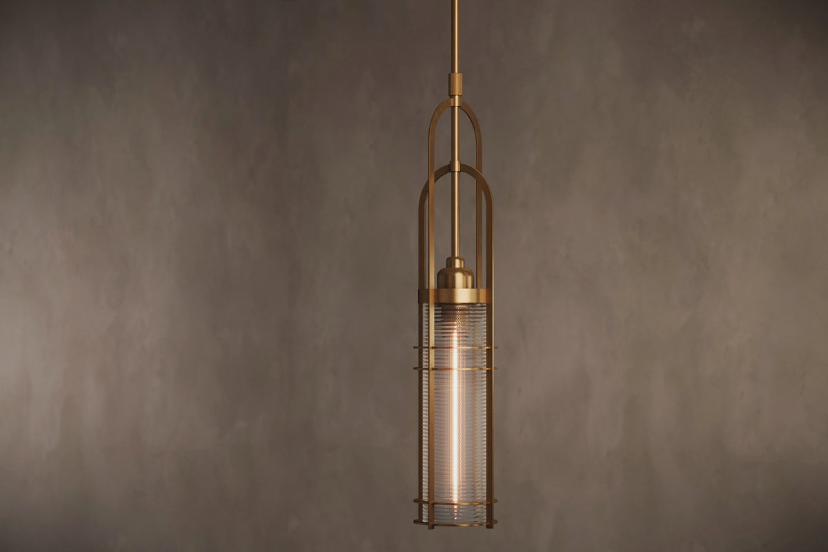 Angled view of the architectural designer Halyard Pendant, a nautically-inspired pendant light featuring hand-finished solid brass and heavy glass for authentic, artisanal elegance.