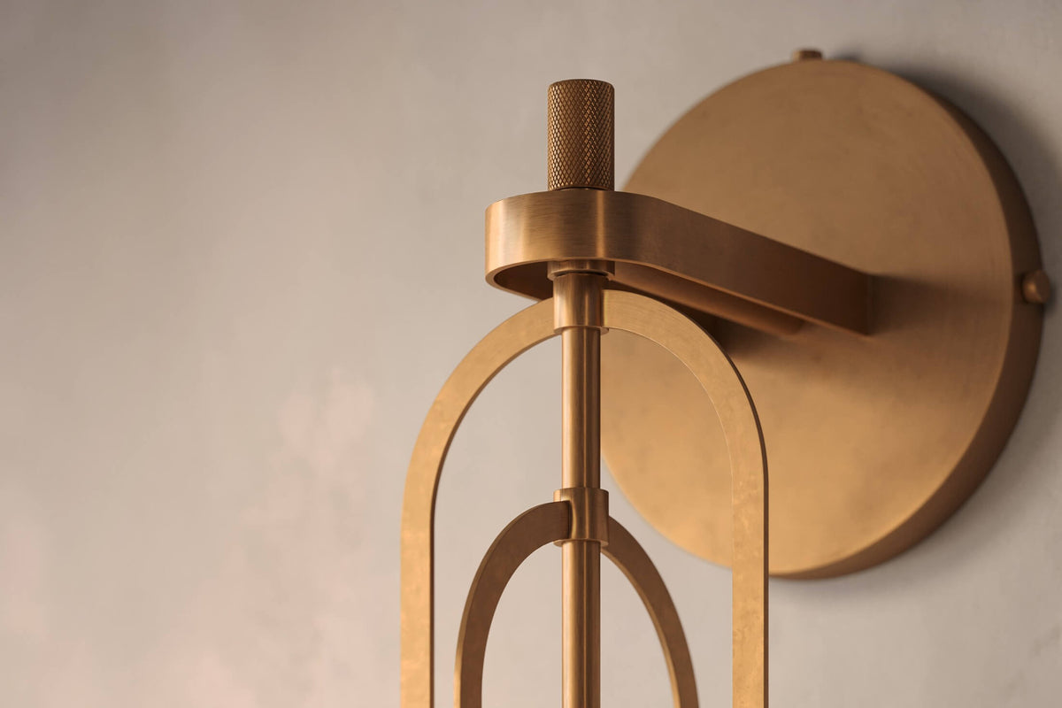Close-up view of the designer Halyard Sconce (Aura), a nautically-inspired decorative wall light featuring hand-finished solid brass and heavy glass for authentic, artisanal elegance.