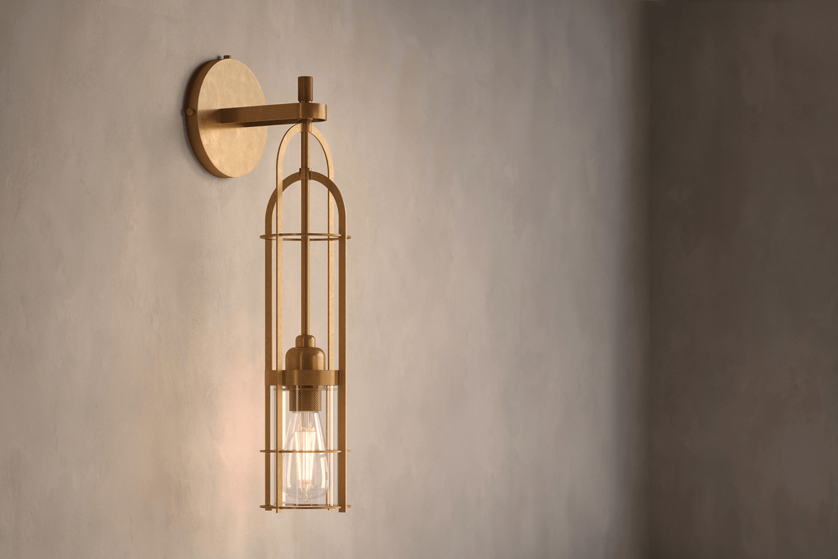 Angled view of the designer Halyard Sconce (Aura), a nautically-inspired wall light featuring hand-finished solid brass and heavy glass for authentic, artisanal elegance.