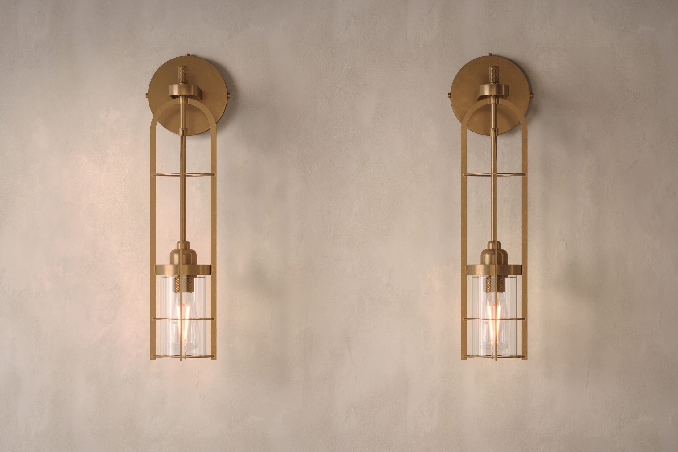 Front view of a pair of designer Halyard Sconces, nautically-inspired wall lights featuring hand-finished solid brass and heavy glass for authentic, artisanal elegance.