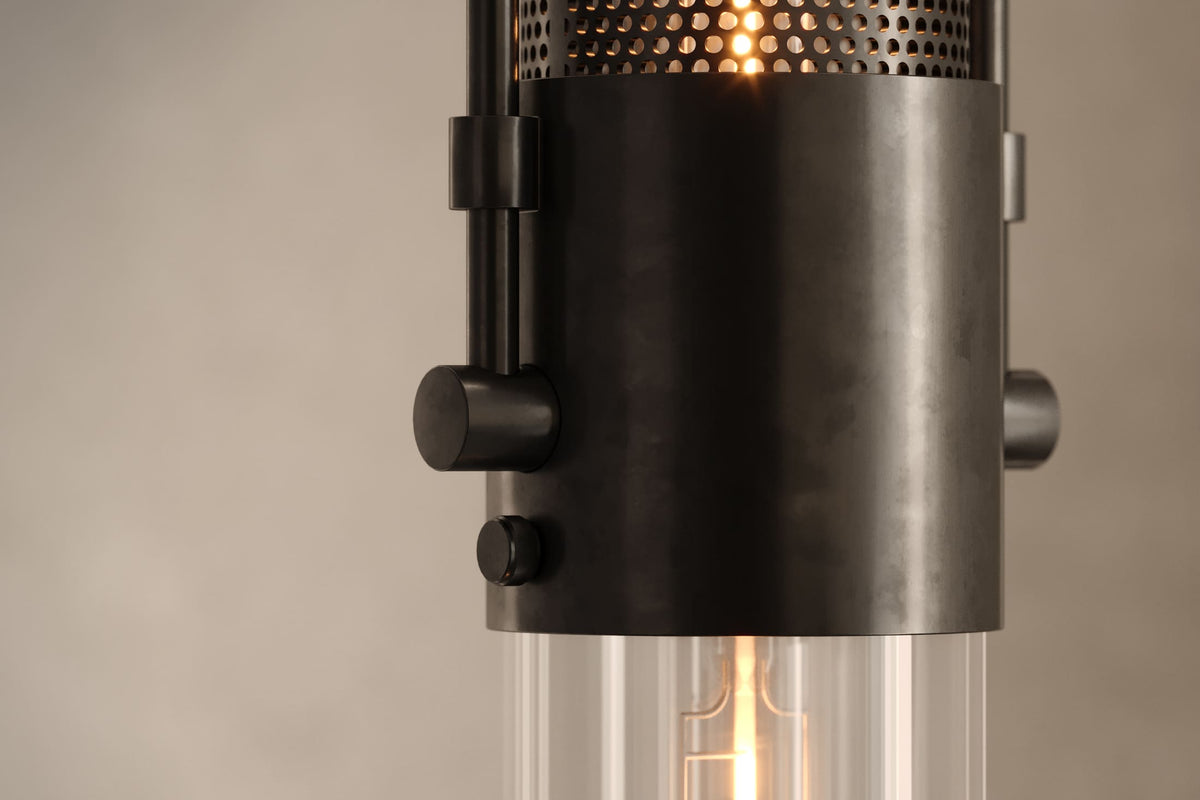 Close-up view of the designer Plumb Pendant, an industrial-inspired decorative pendant light featuring hand-finished perforated steel and heavy glass for genuine, utilitarian elegance.