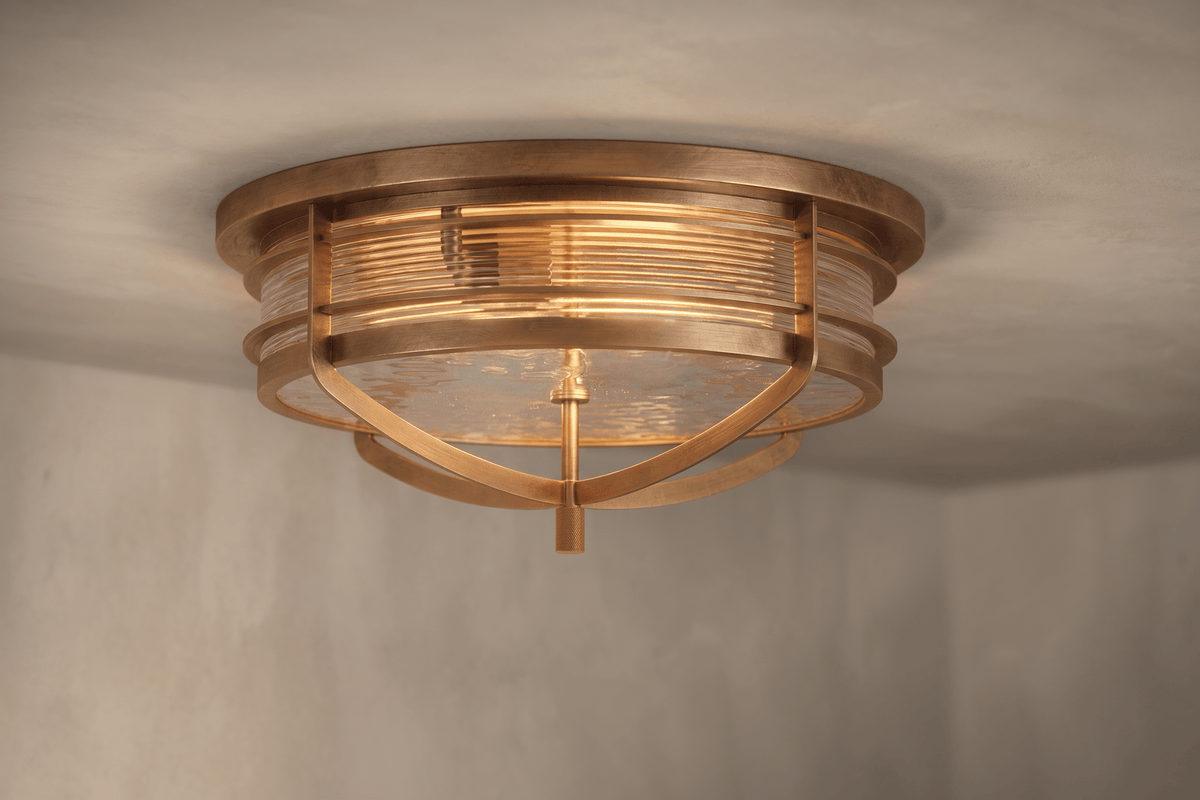 Angled view of the architectural designer Zenith Flush Mount, a nautically-inspired ceiling light featuring hand-finished solid brass and heavy glass for authentic, artisanal elegance.