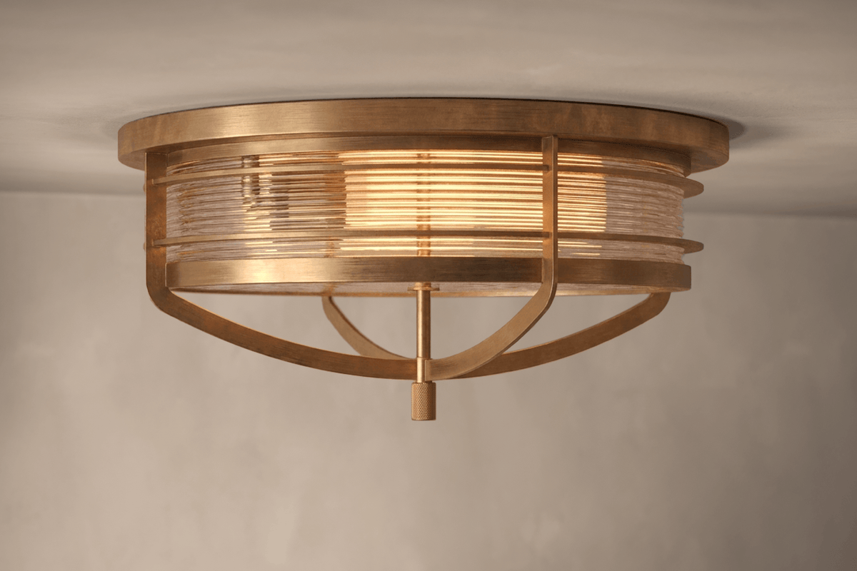 Angled view of the designer Zenith Flush Mount, a nautically-inspired ceiling light featuring hand-finished solid brass and heavy glass for authentic, artisanal elegance.